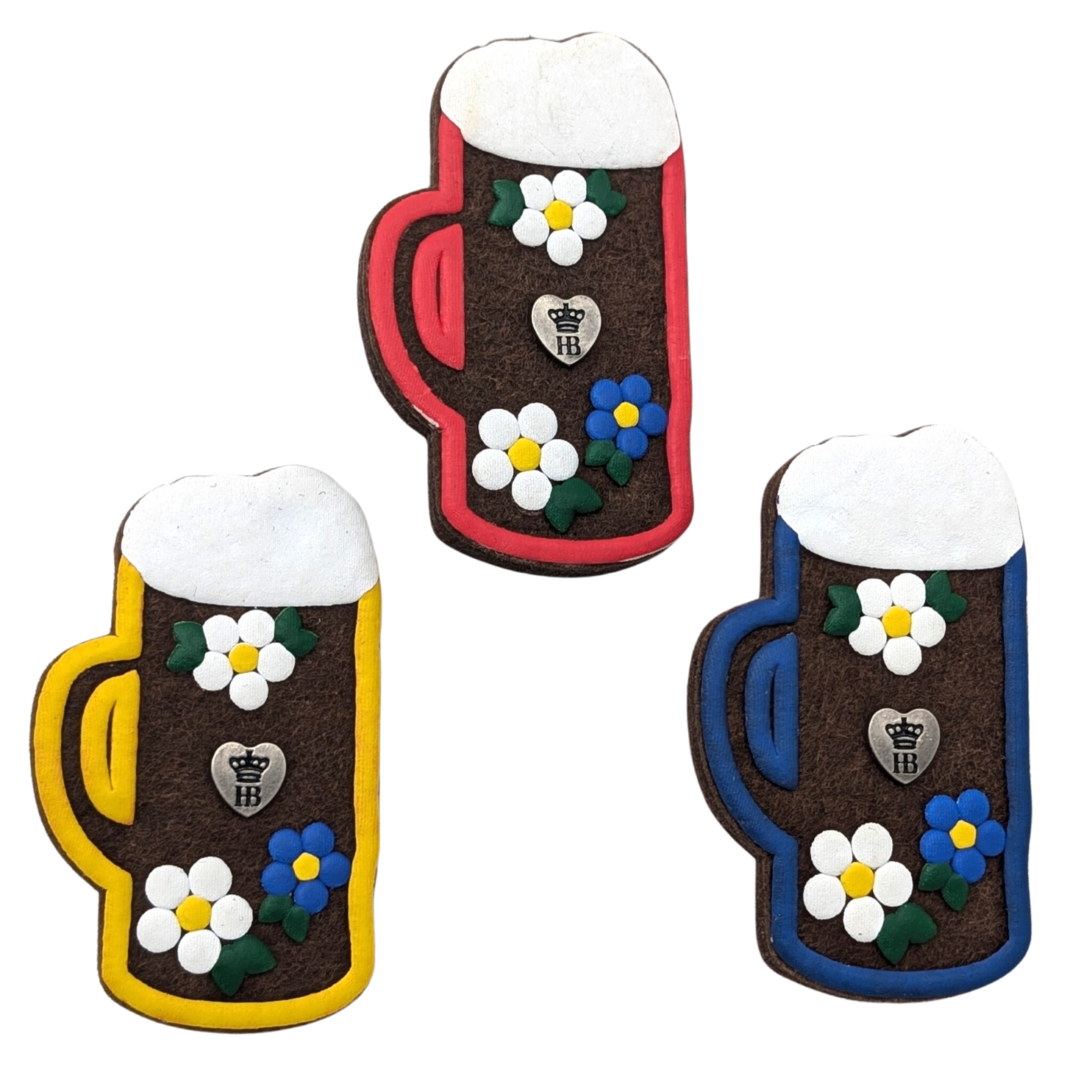 Drei dekorative Bierkrug-Anstecker mit Schaumkrone, jeweils mit rotem, blauem und gelbem Rand, verziert mit weiß-blauen Blumen und einem kleinen Herz in der Mitte.