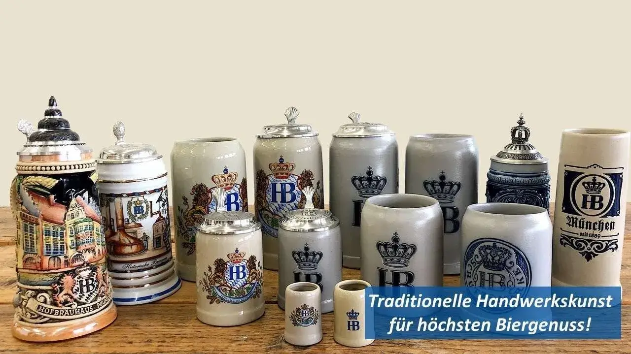 Sammlung verschiedener Hofbräuhaus-Bierkrüge in traditionellem Design, mit und ohne Zinndeckel, auf Holztisch vor hellem Hintergrund.