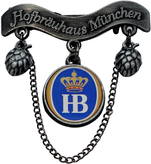 Dekorativer Metall-Anstecker mit einem oberen Banner, auf dem „Hofbräuhaus München“ steht. Darunter hängen zwei stilisierte Hopfendolden seitlich herab. In der Mitte befindet sich ein rundes Emblem mit blauem Hintergrund, goldener Krone und den weißen Buc