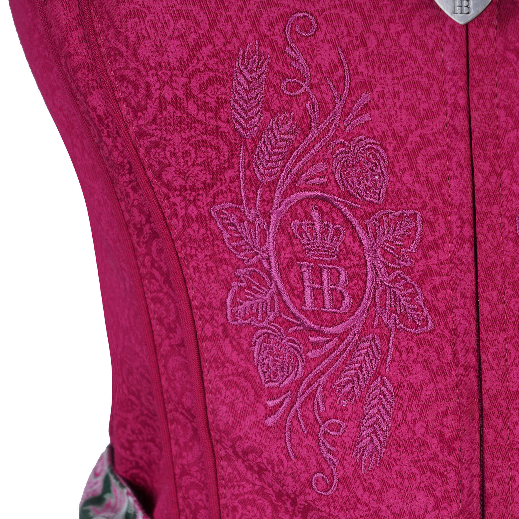Detailaufnahme des pinken Dirndl-Mieders mit floraler Struktur und einer aufgestickten „HB“-Krone in der Mitte, umgeben von Hopfen- und Gerstenährenmotiven.